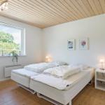Bedroom with double bed, window, and bedside table.