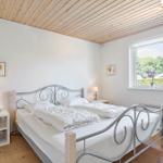 Bedroom with double bed, wooden floor, and window view