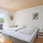 Bedroom with bed, window, and wooden ceiling.
