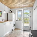 Room with washing machine, sink, and door to outdoor area.