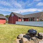 Red house with grill area and green lawn. Satellite dish and windows visible.