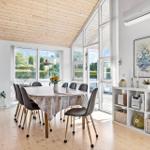 Dining room with round table, chairs, and large windows to the outdoor terrace.