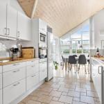 Kitchen with white cabinets, wooden countertops, and view of dining area.