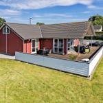 Red vacation house with terrace and garden. Outdoor area with seating.