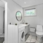 Bathroom with washing machine, toilet, and shower.