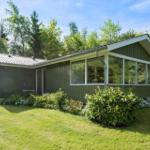 A green house with large windows and garden