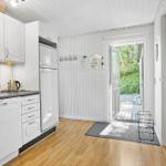 Kitchen with white cabinets, refrigerator, and doorway to terrace.