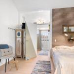 Bedroom with bed, wood panel, view to balcony