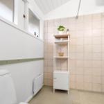 Bathroom with toilet, shower area, and small shelf