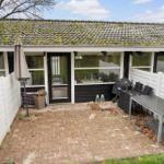Terrace with table, chairs, and grill. Backyard with white fence and black entrance door.