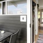 Outdoor area with table and chairs. Entrance to interior with rug.