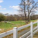 Large garden with playground and view of water and forest.