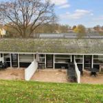 House with terrace, garden, and view of woods and hills.
