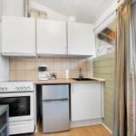 Kitchen with white cabinets, stove, refrigerator, and window.