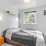Bedroom with bed, window, and wall lamps.