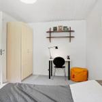 Bedroom with desk, wardrobe, and seating area.