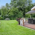 Backyard with terrace, garden, and forest in the background.