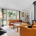 Living room with brown leather sofas, fireplace, and glass doors to terrace.