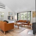Living room with brown leather furniture, fireplace, and sleeping area above.