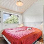 Bedroom with bed, window and white walls.