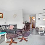 Living and dining area with sofa, leather chair, and table