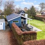 Blue vacation home with terrace and garden. Attached shed.