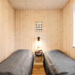 Two beds in a room with wood-paneled walls and window