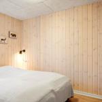 Bedroom with wooden walls, bed, and window.