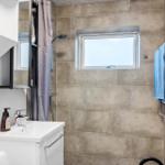 Bathroom with shower, window, and towel rack.