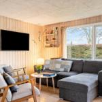 Living room with sofa, chairs, and TV mounted on wood wall