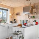 Kitchen with wooden walls, white countertop, and kitchen island.