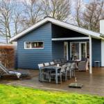 Blue wooden cabin with terrace, garden furniture, and barbecue area.