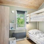 Room with bunk bed, window, and wooden floor.