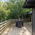 Wooden terrace with seating area and view into the forest.