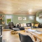 Living and dining area with wooden ceiling, sofa, dining table, and fireplace.