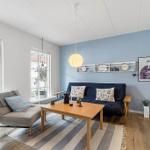 Living room with blue wall, sofa, coffee table, and windows to terrace.