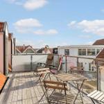 Terrace with table, chairs, and view of rooftops.