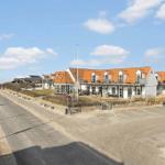 Row house with orange roof and balconies along the seaside road.