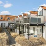 Modern holiday homes with balconies and red tiled roofs in a well-maintained setting.