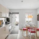 Kitchen and dining area with table, chairs, and window.