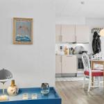 Kitchen and dining area with table, chairs, and cabinets. Glasses are on the table.