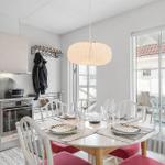 Kitchen and dining area with table, chairs, and window to terrace.