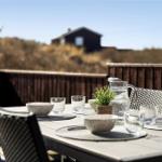 Covered balcony with table, chairs, and view of the house.