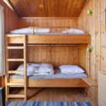 Room with wooden bunk bed, window, and wall art