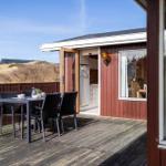 Deck with table and chairs, view of the coastal landscape.