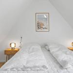 Bedroom with double bed, two nightstands, and wall decoration.