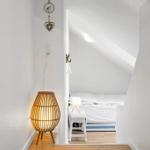 Bedroom with sloped ceiling, bed and standing lamp