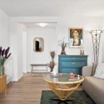 Living room with sofa, coffee table, and TV mounted on the wall.