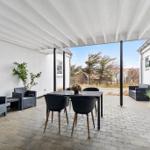 Terrace with seating group, table and chairs under white roof