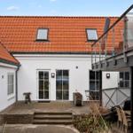 House with red roof, terrace, and glass railing